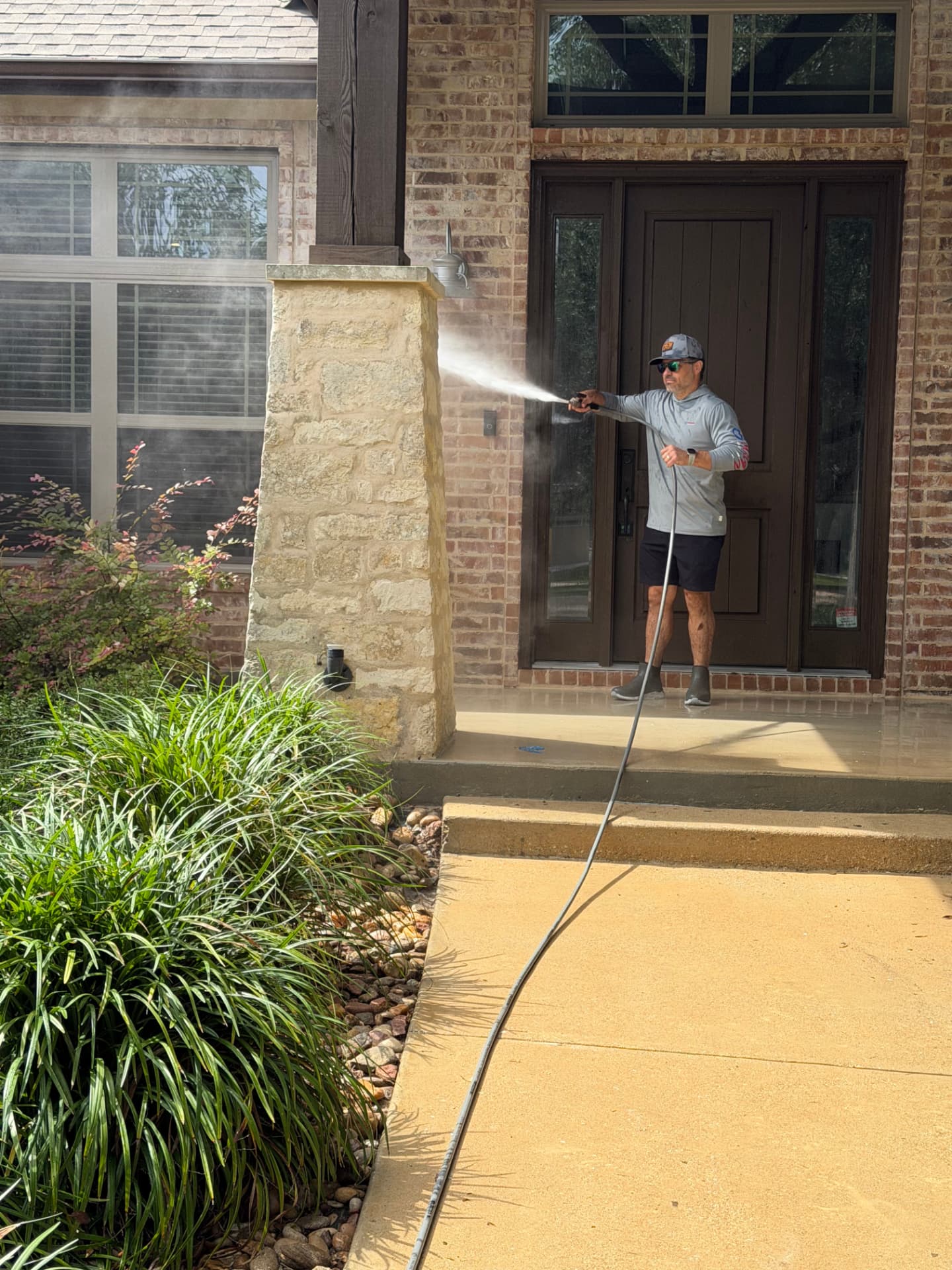 Armor Wash Solutions technician soft washing a home entryway in Austin, TX